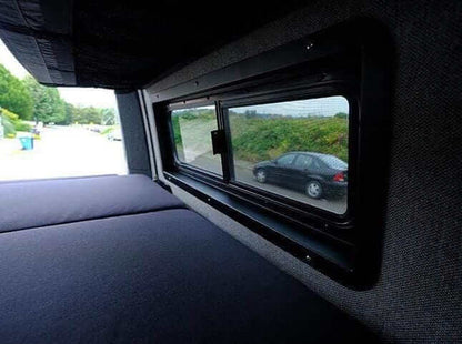 Finished CRL pill window with Flatline trim kit in a camper van