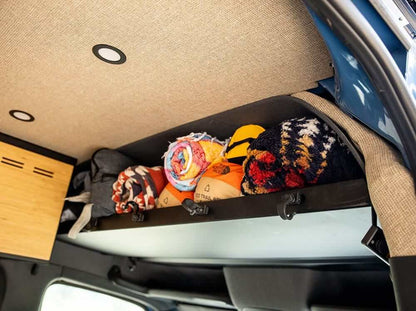 Sprinter headliner shelf loaded with blankets above the cab